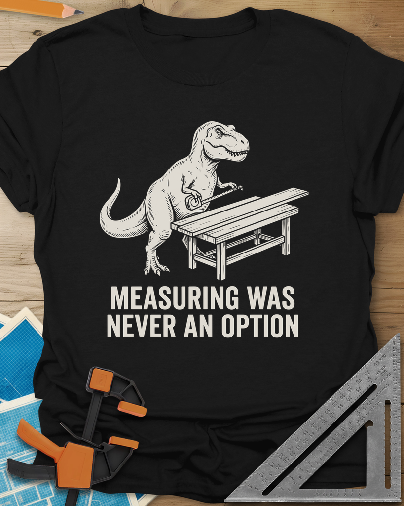 Dino Measuring t-shirt in Black, a T. rex with a tape measure beside a plank workbench