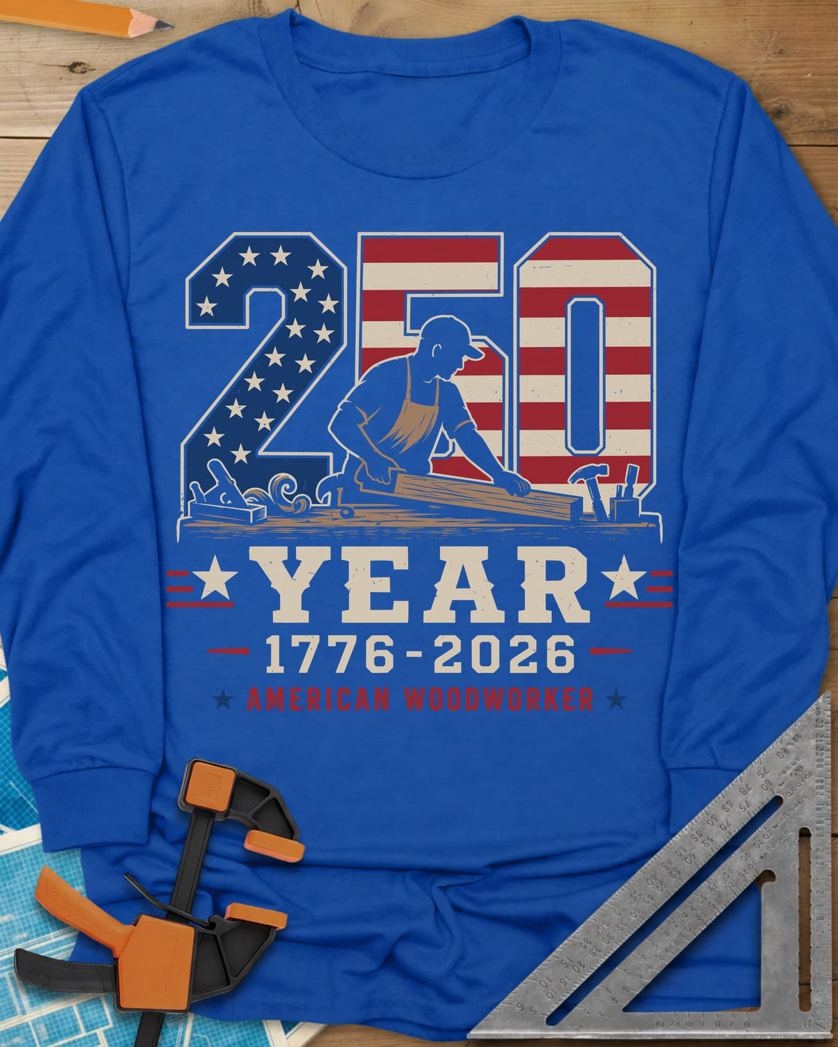 250 Year American Woodworker long sleeve shirt in Royal, stars-and-stripes 250 with a woodworker planing a board