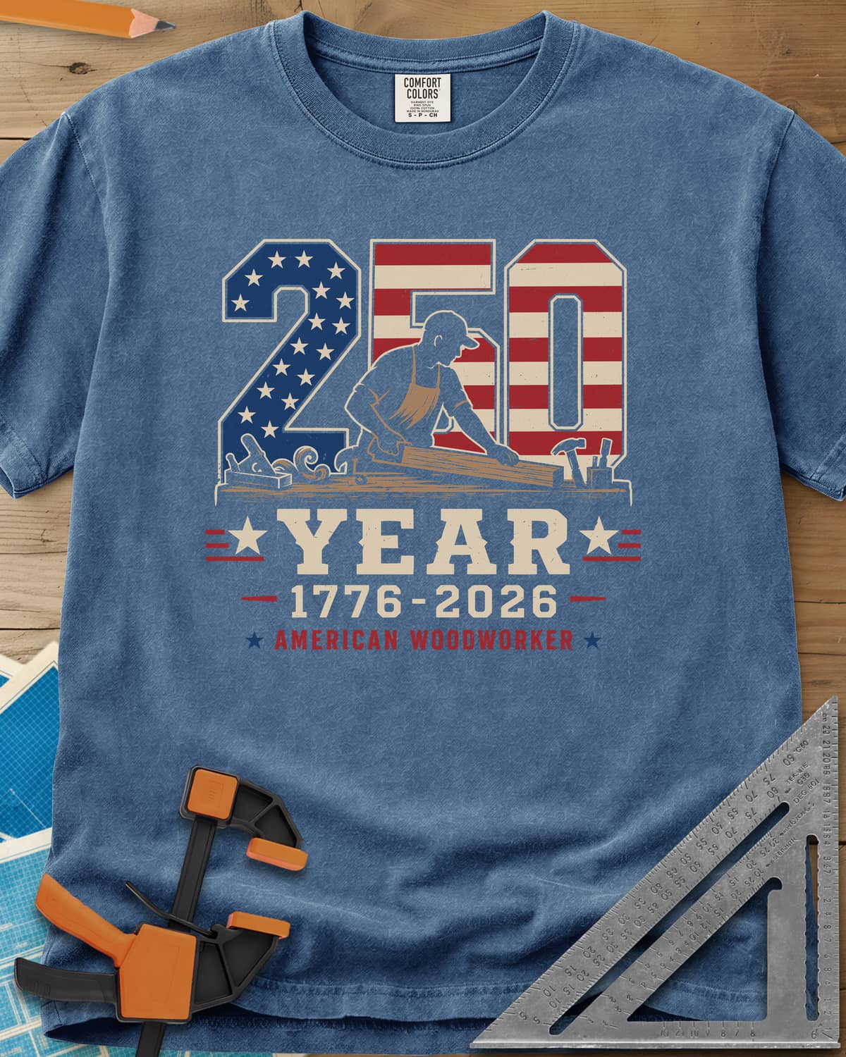 250 Year American Woodworker heavyweight tee in Blue Jean, stars-and-stripes 250 with a woodworker planing a board