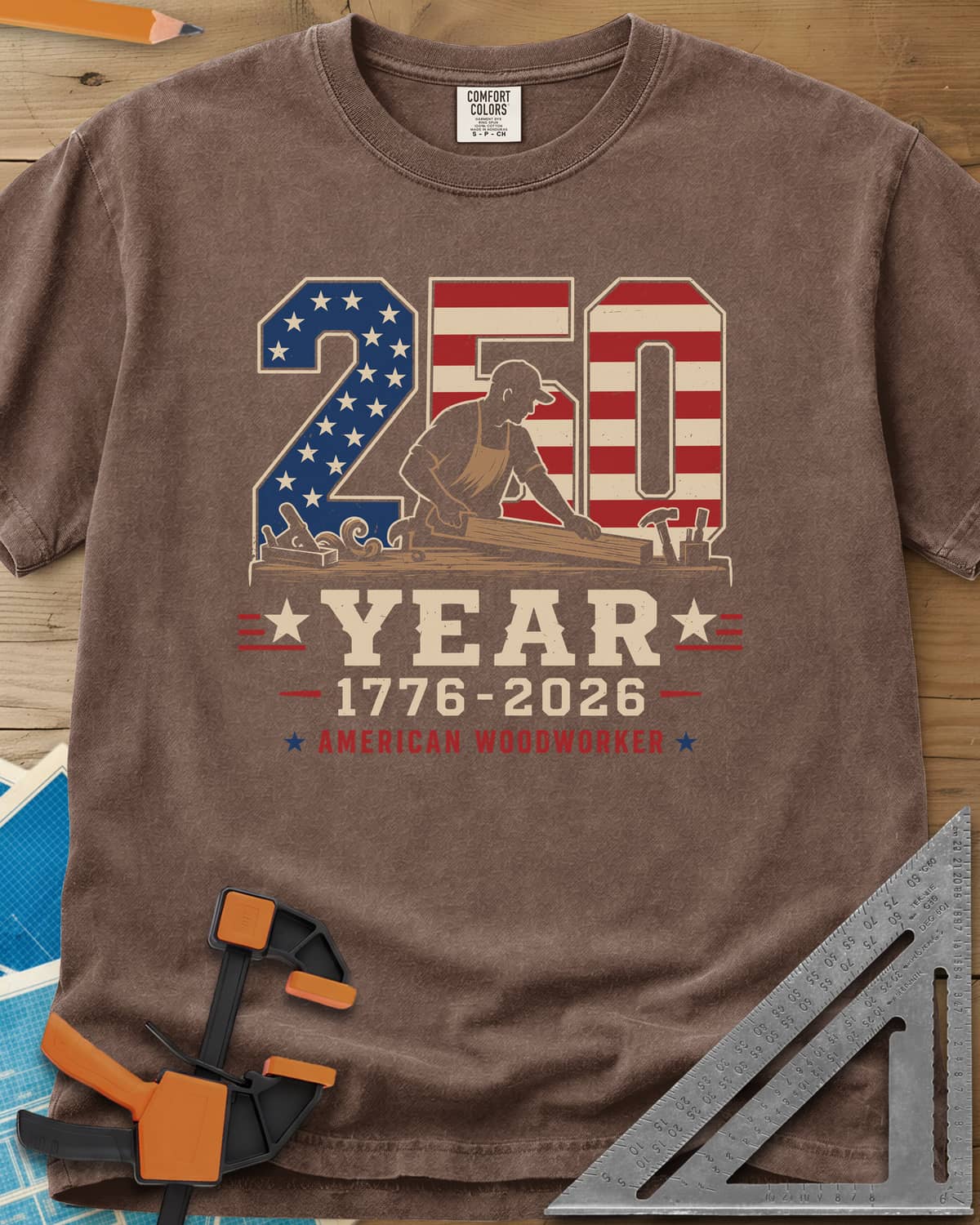 250 Year American Woodworker heavyweight tee in Espresso, stars-and-stripes 250 with a woodworker planing a board