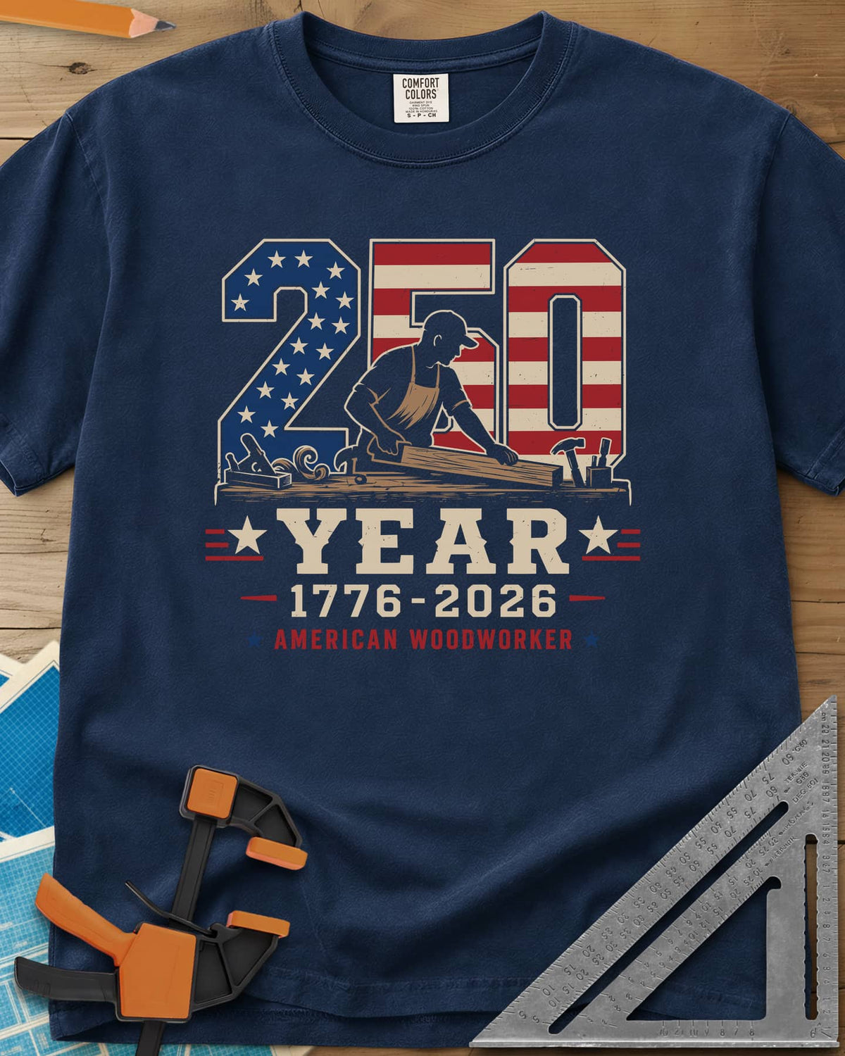 250 Year American Woodworker heavyweight tee in Navy, stars-and-stripes 250 with a woodworker planing a board