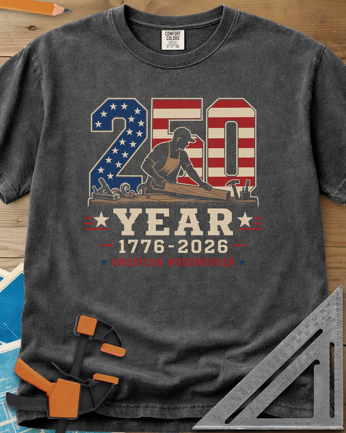 250 Year American Woodworker heavyweight tee in Pepper, stars-and-stripes 250 with a woodworker planing a board