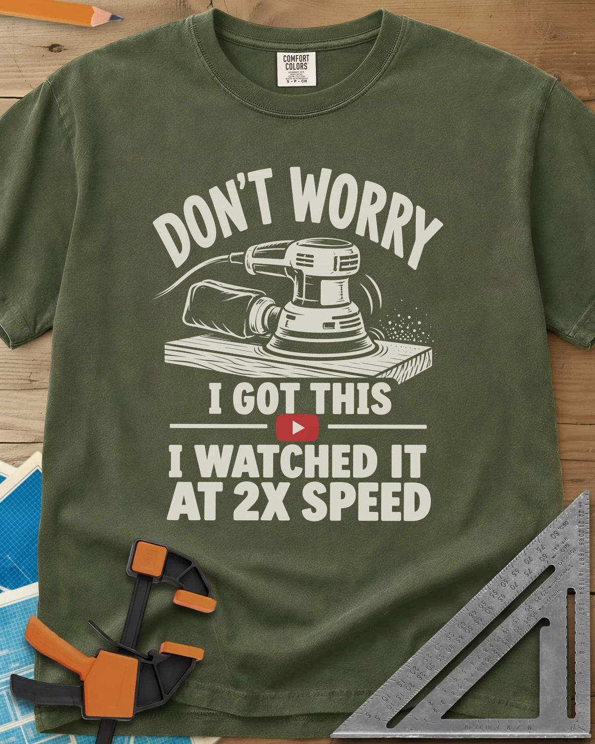 2x Speed heavyweight tee in Hemp, an orbital sander on a board beside a red video play button