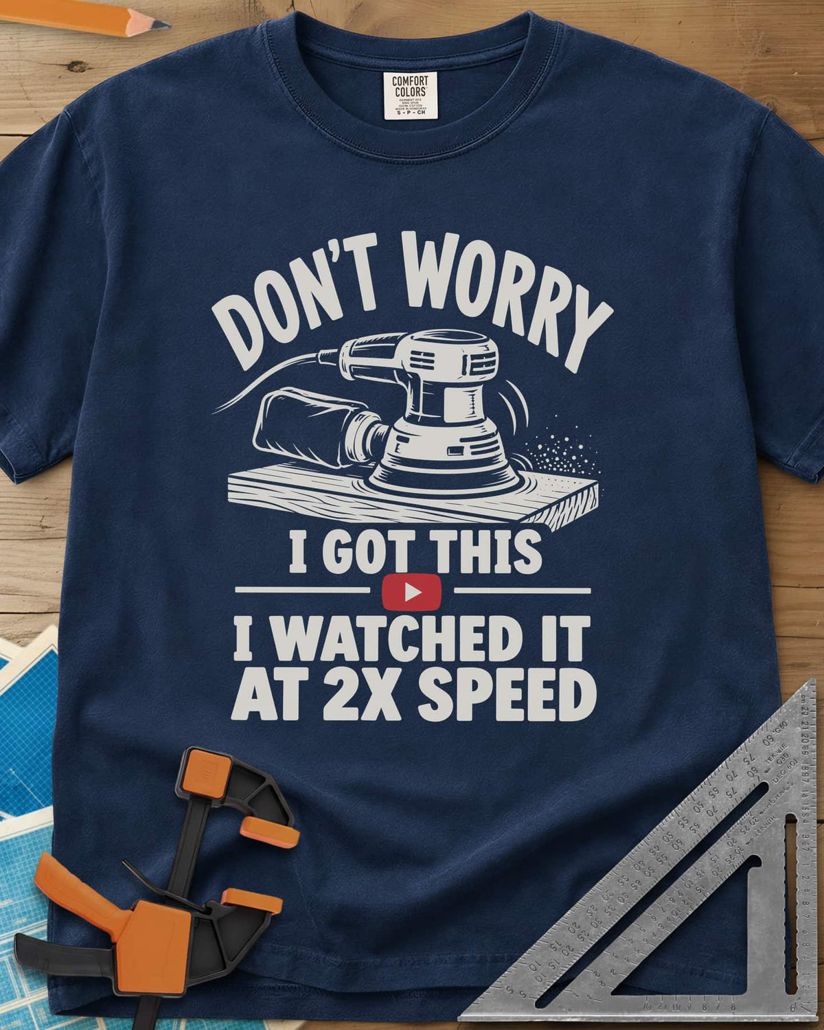 2x Speed heavyweight tee in Navy, an orbital sander on a board beside a red video play button