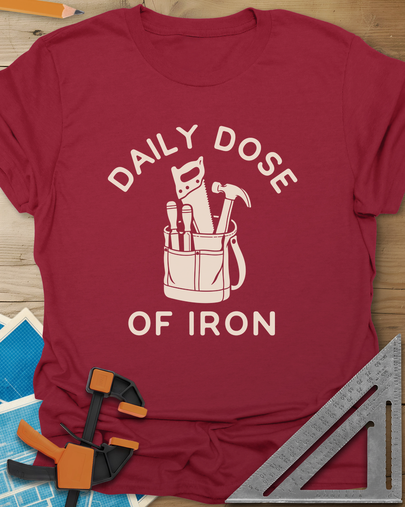 Daily Dose t-shirt in Cardinal Red, a canvas tool bag holding a handsaw, hammer and two chisels