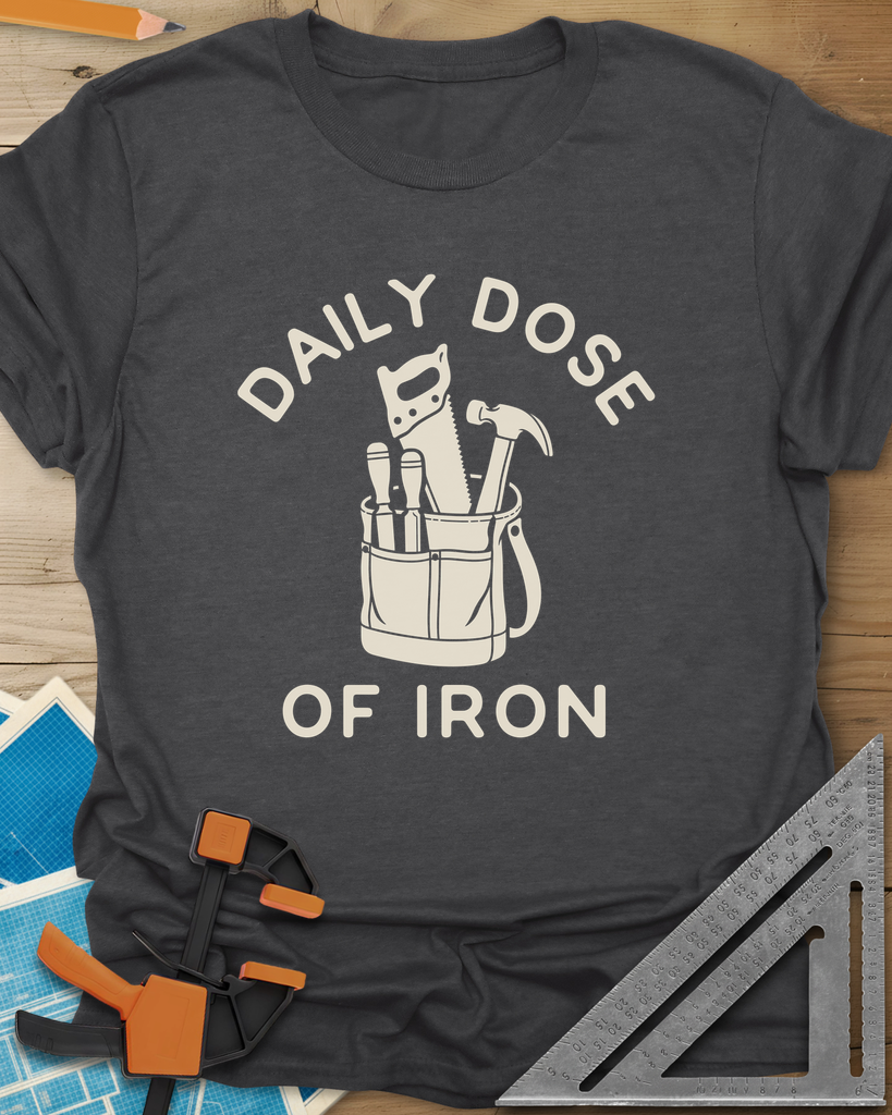 Daily Dose t-shirt in Dark Heather Grey, a canvas tool bag holding a handsaw, hammer and two chisels