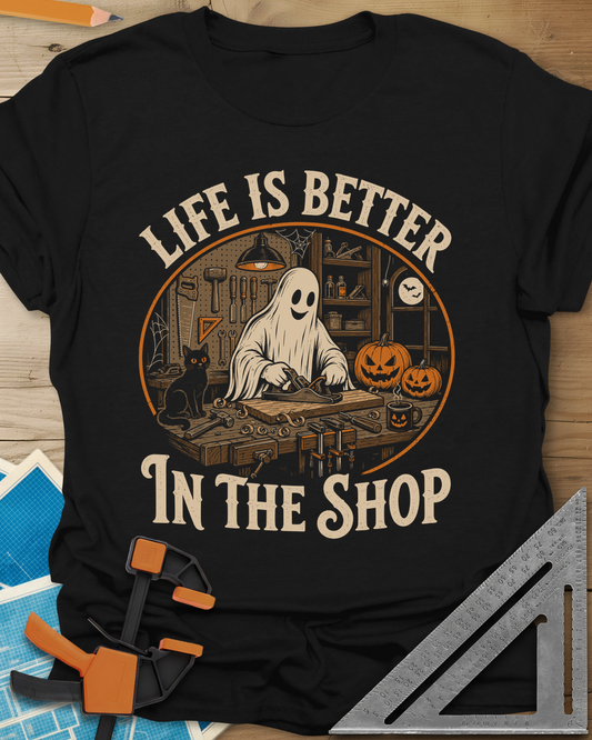 Shop Life t-shirt in Black, a smiling ghost planing a board beside a cat and pumpkins