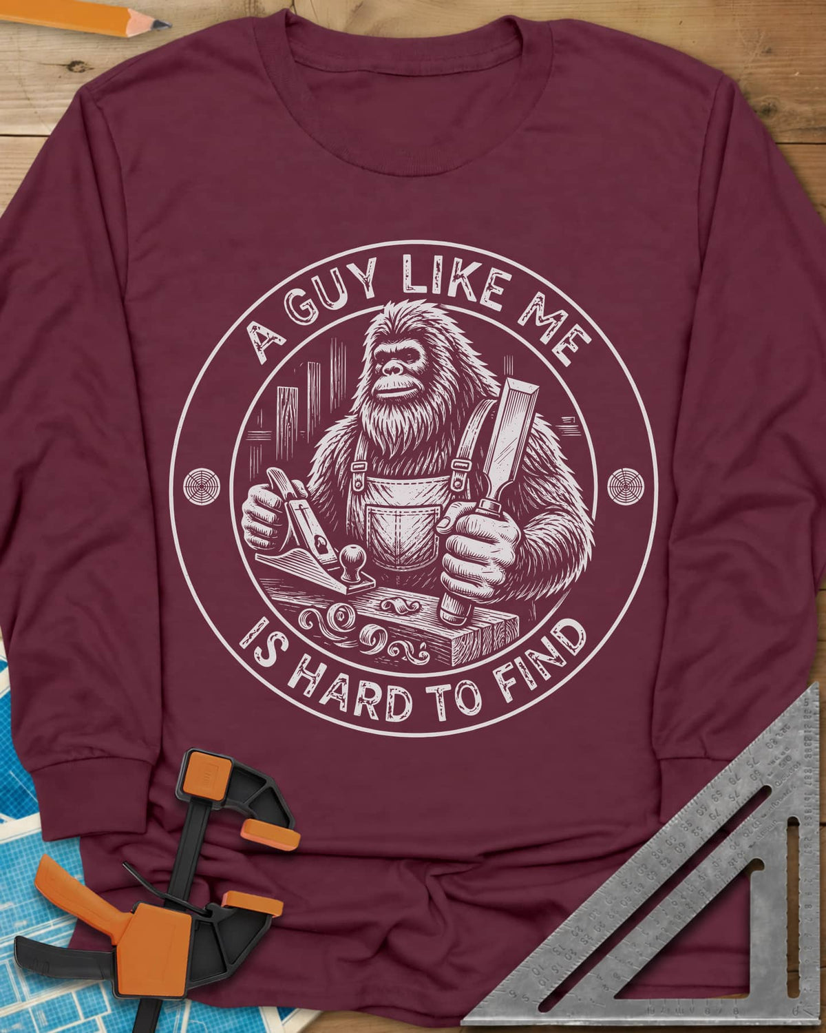 A Guy Like Me Is Hard To Find Woodworking long sleeve shirt in Maroon, Bigfoot in overalls with a hand plane and chisel
