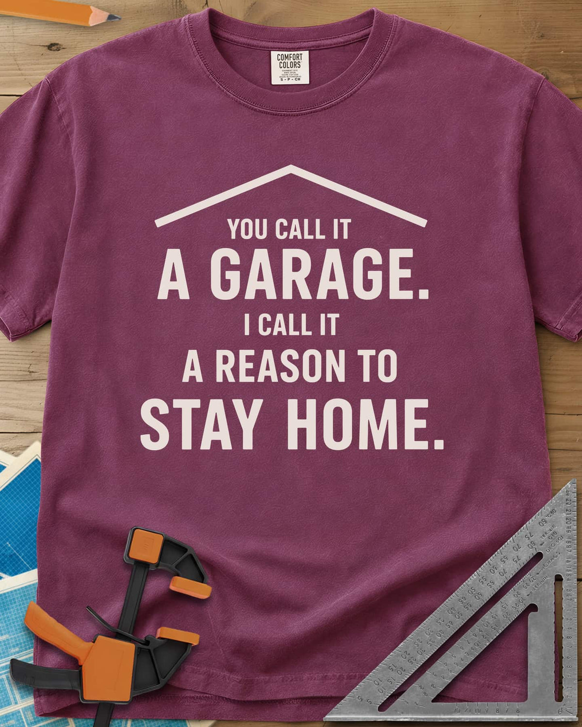A Reason To Stay Home heavyweight tee in Berry, a simple roofline above bold two-tone lettering