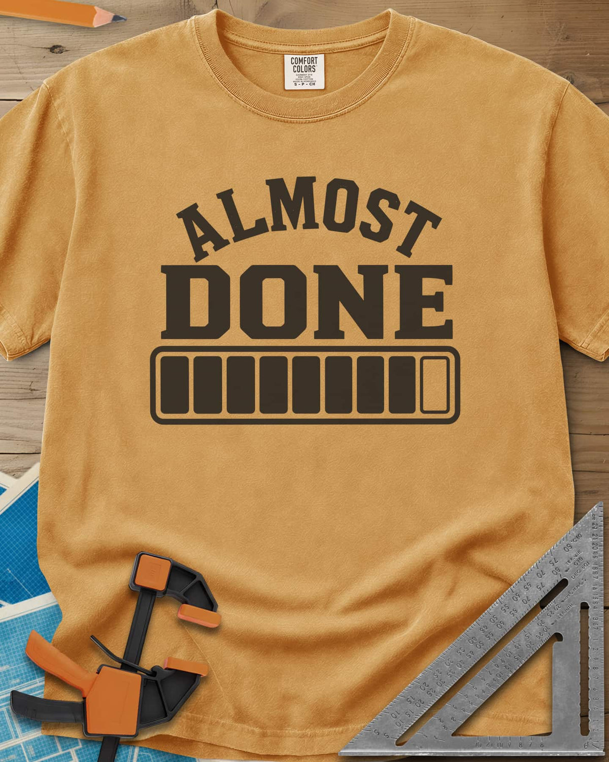 Almost Done heavyweight tee in Mustard, bold ALMOST DONE lettering over a nearly full loading bar