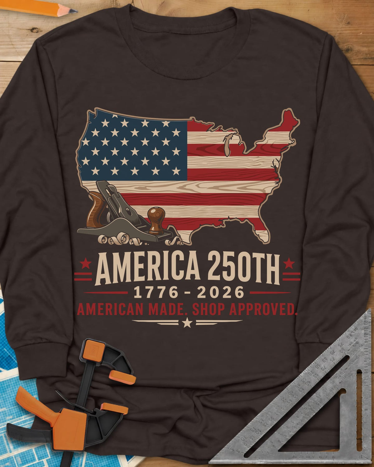 America 250th Shop Approved long sleeve shirt in Dark Chocolate, a US map filled with a wood-plank flag, a hand plane and