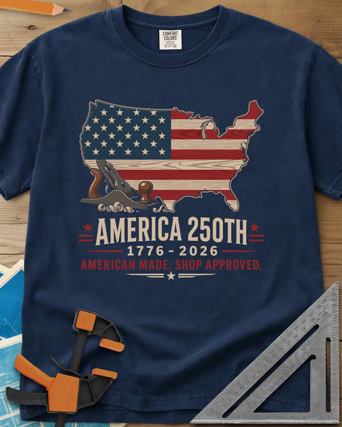 America 250th Shop Approved heavyweight tee in Navy, a US map filled with a wood-plank flag, a hand plane and curls