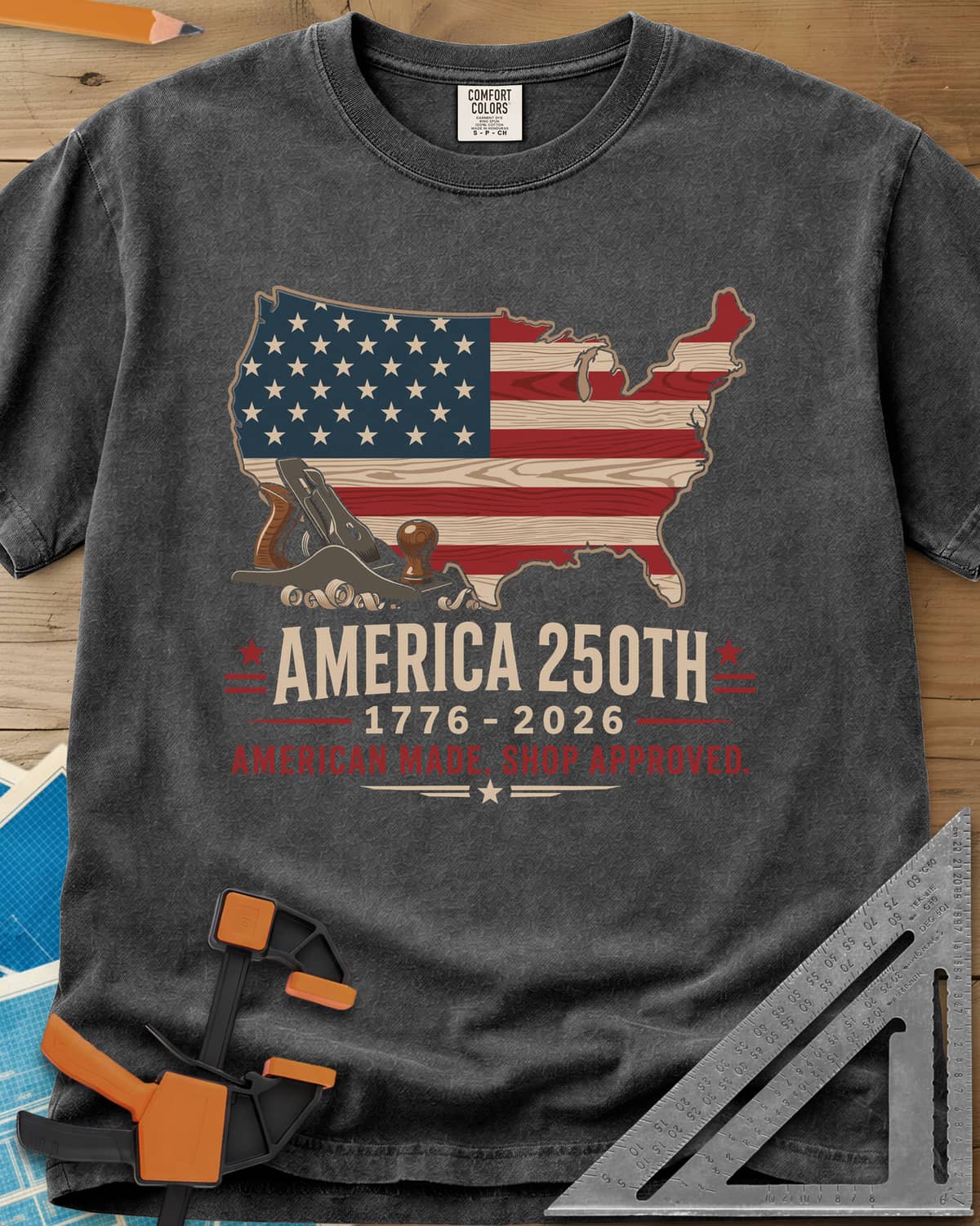 America 250th Shop Approved heavyweight tee in Pepper, a US map filled with a wood-plank flag, a hand plane and curls