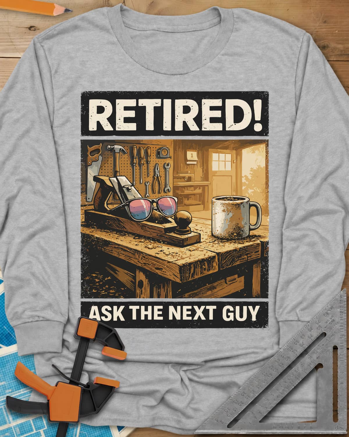 Ask The Next Guy long sleeve shirt in Sport Grey, a sunlit workbench with a hand plane, sunglasses and a coffee mug
