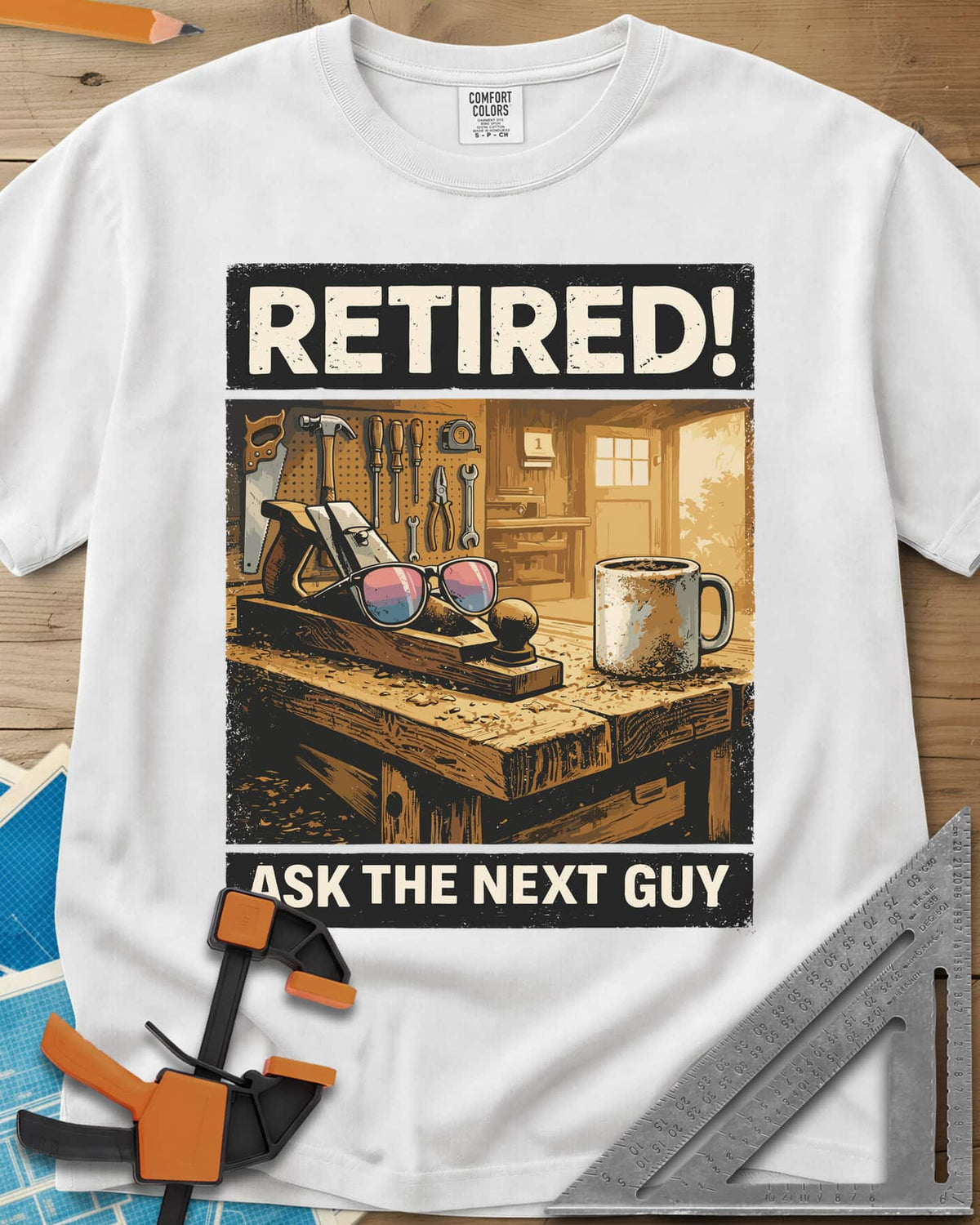 Ask The Next Guy heavyweight tee in White, a sunlit workbench with a hand plane, sunglasses and a coffee mug