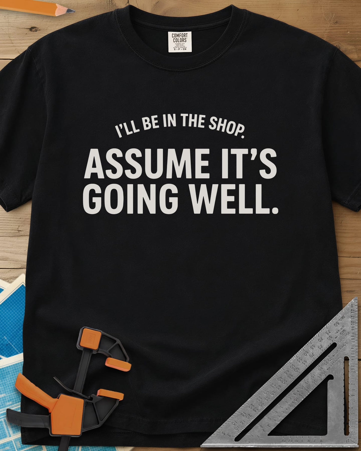 Assume It's Going Well heavyweight tee in Black, bold two-line lettering with a small arched line above