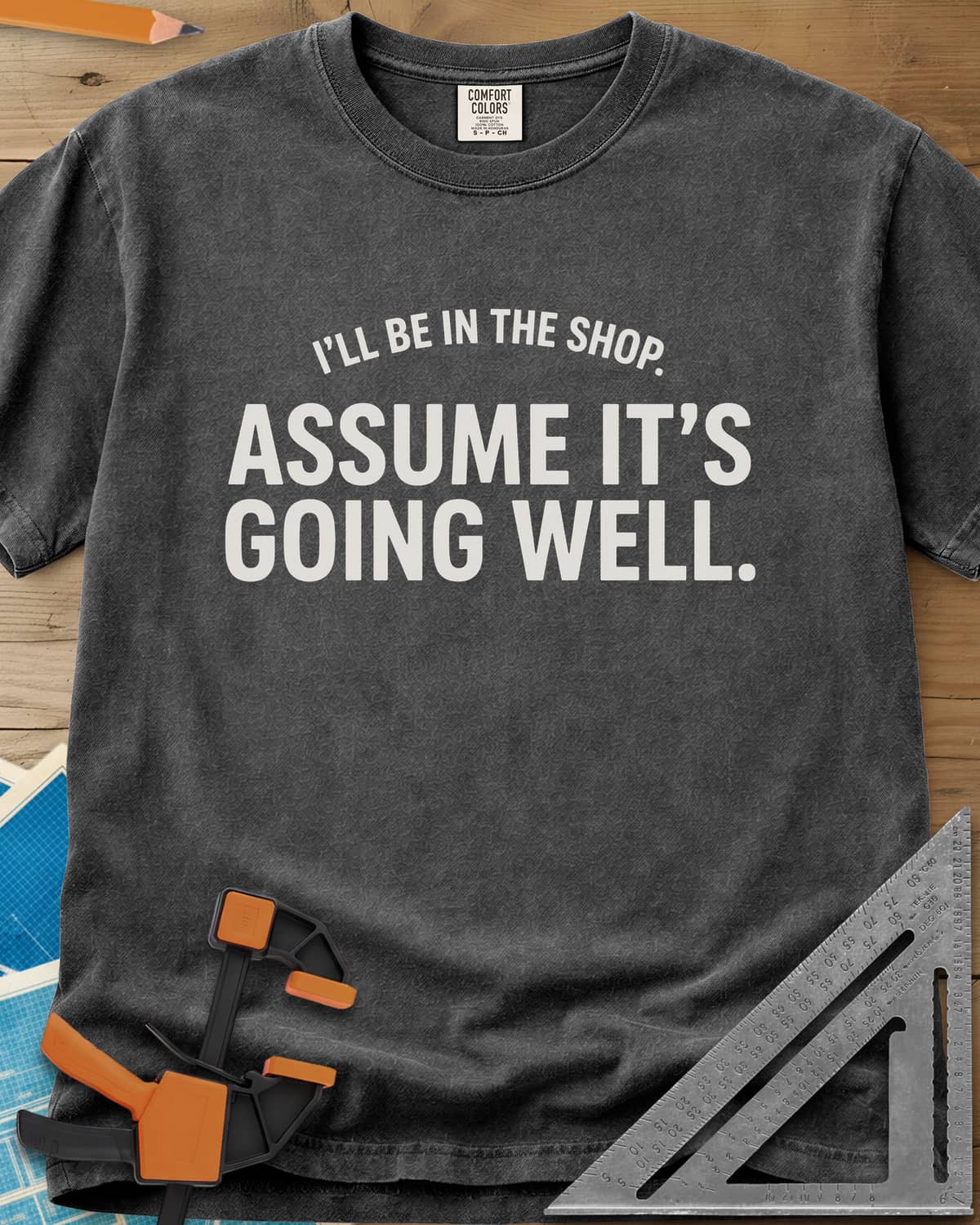 Assume It's Going Well heavyweight tee in Pepper, bold two-line lettering with a small arched line above