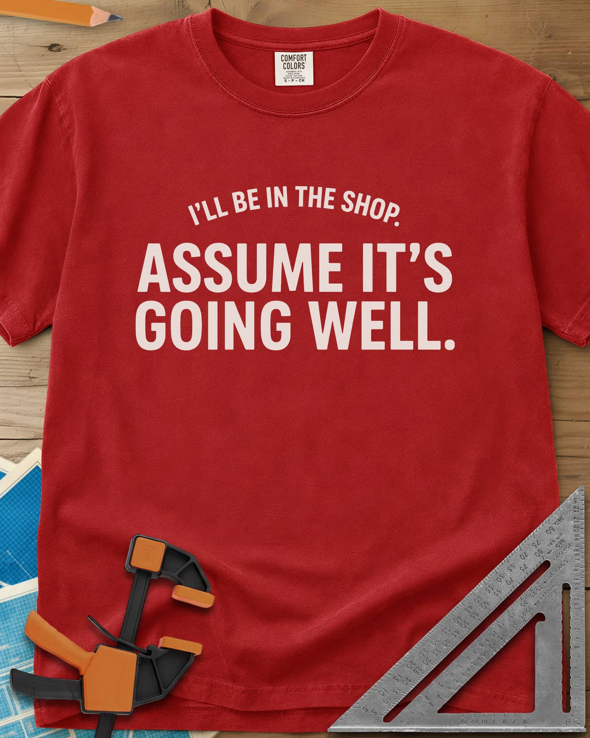 Assume It's Going Well heavyweight tee in Red, bold two-line lettering with a small arched line above