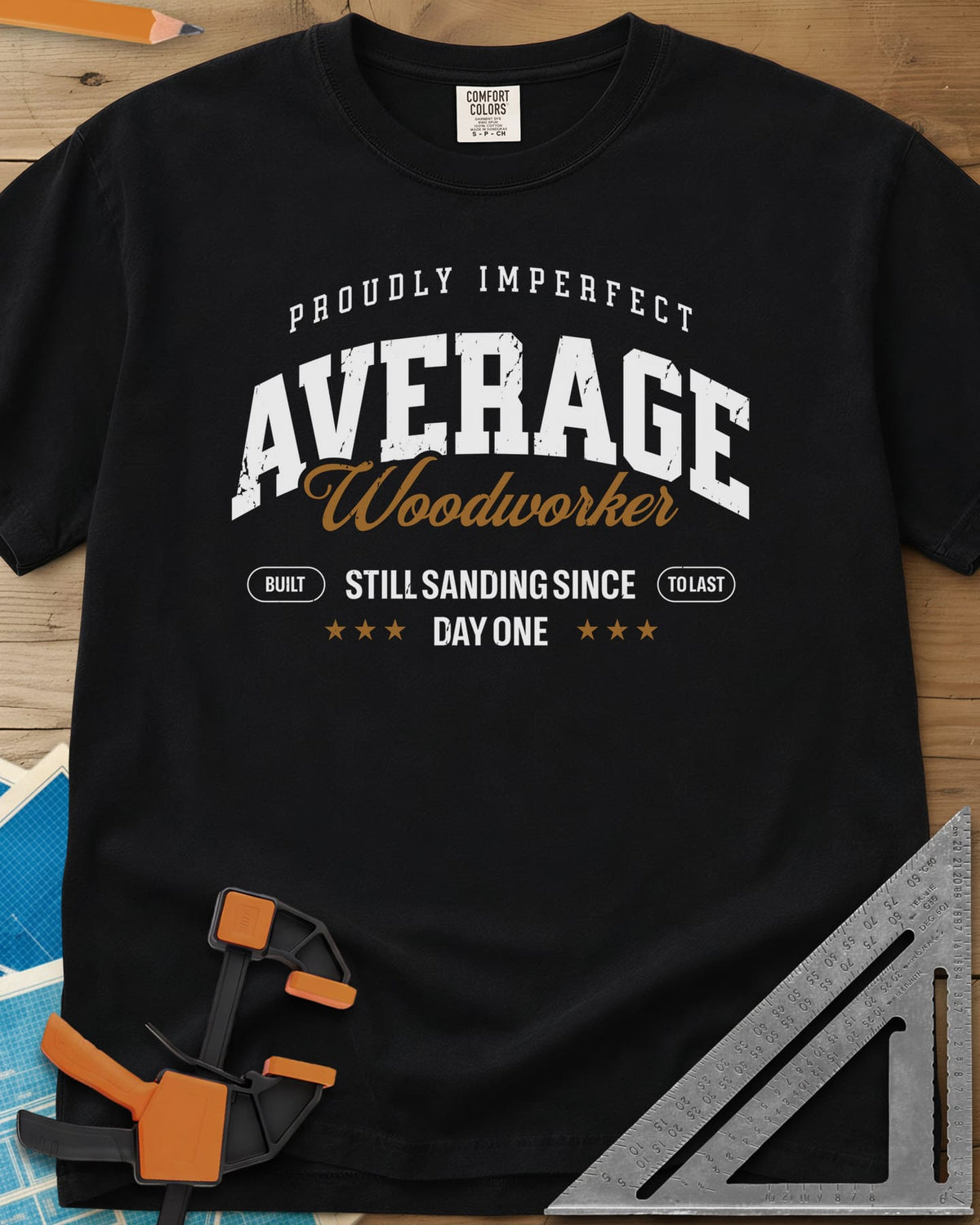 Average Woodworker heavyweight tee in Black, varsity AVERAGE over gold script Woodworker, with badges and stars