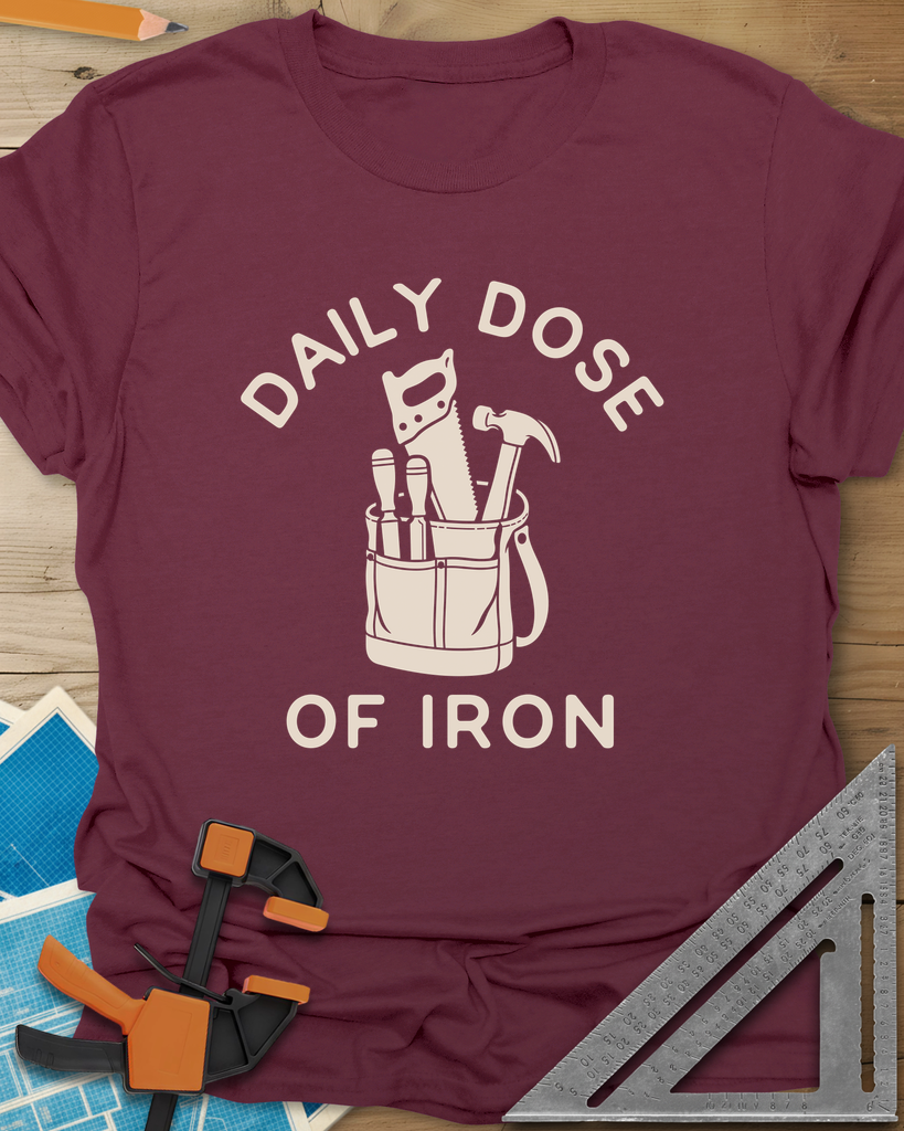 Daily Dose t-shirt in Maroon, a canvas tool bag holding a handsaw, hammer and two chisels