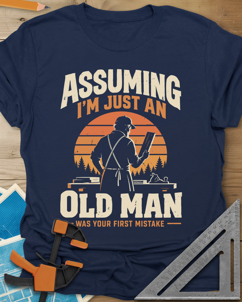 Old Man Mistake t-shirt in Navy, a woodworker in an apron holding a board before a striped sunset