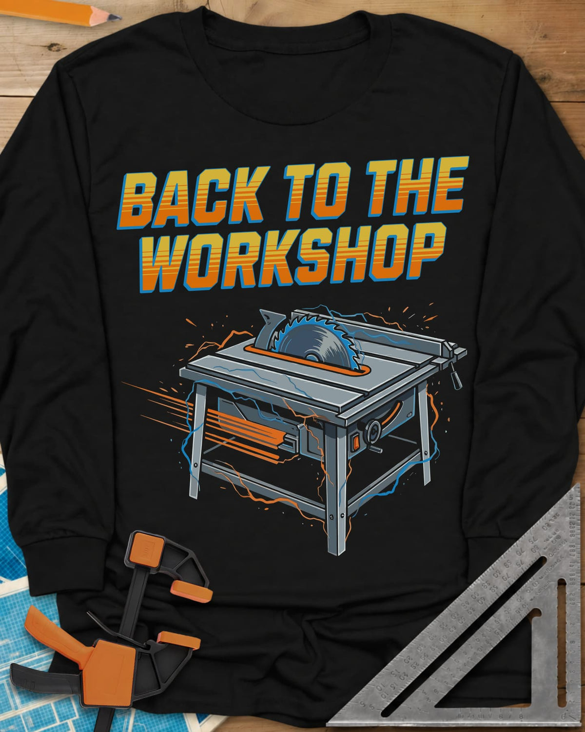 Back To The Workshop long sleeve shirt in Black, a table saw crackling with blue electricity and speed streaks