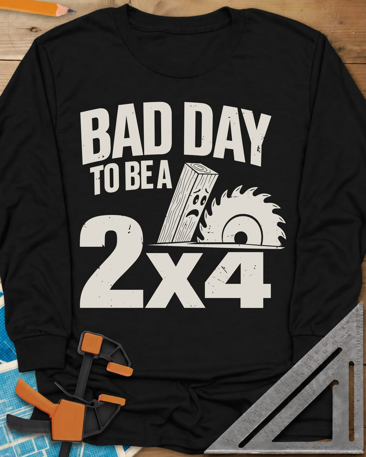 Bad Day 2x4 long sleeve shirt in Black, a 2x4 board with a worried face beside a circular saw blade