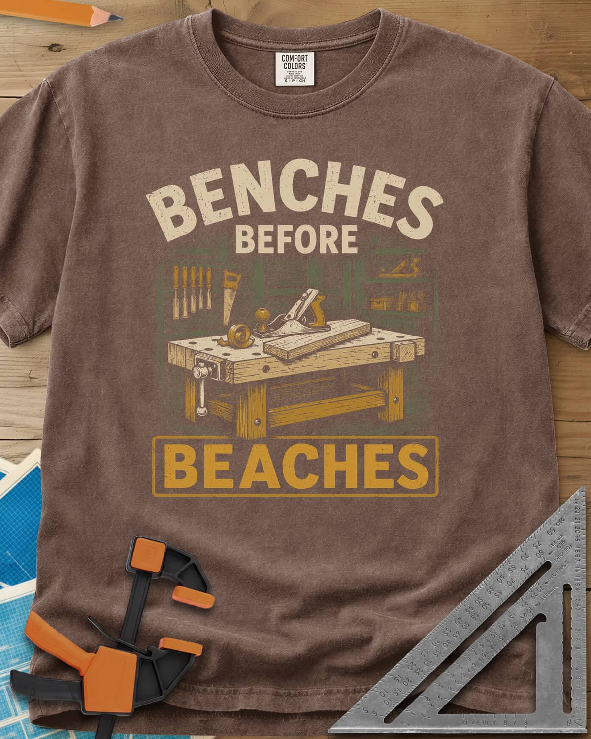 Benches Before Beaches heavyweight tee in Espresso, a woodworking bench with a hand plane, chisels and a saw on the wall