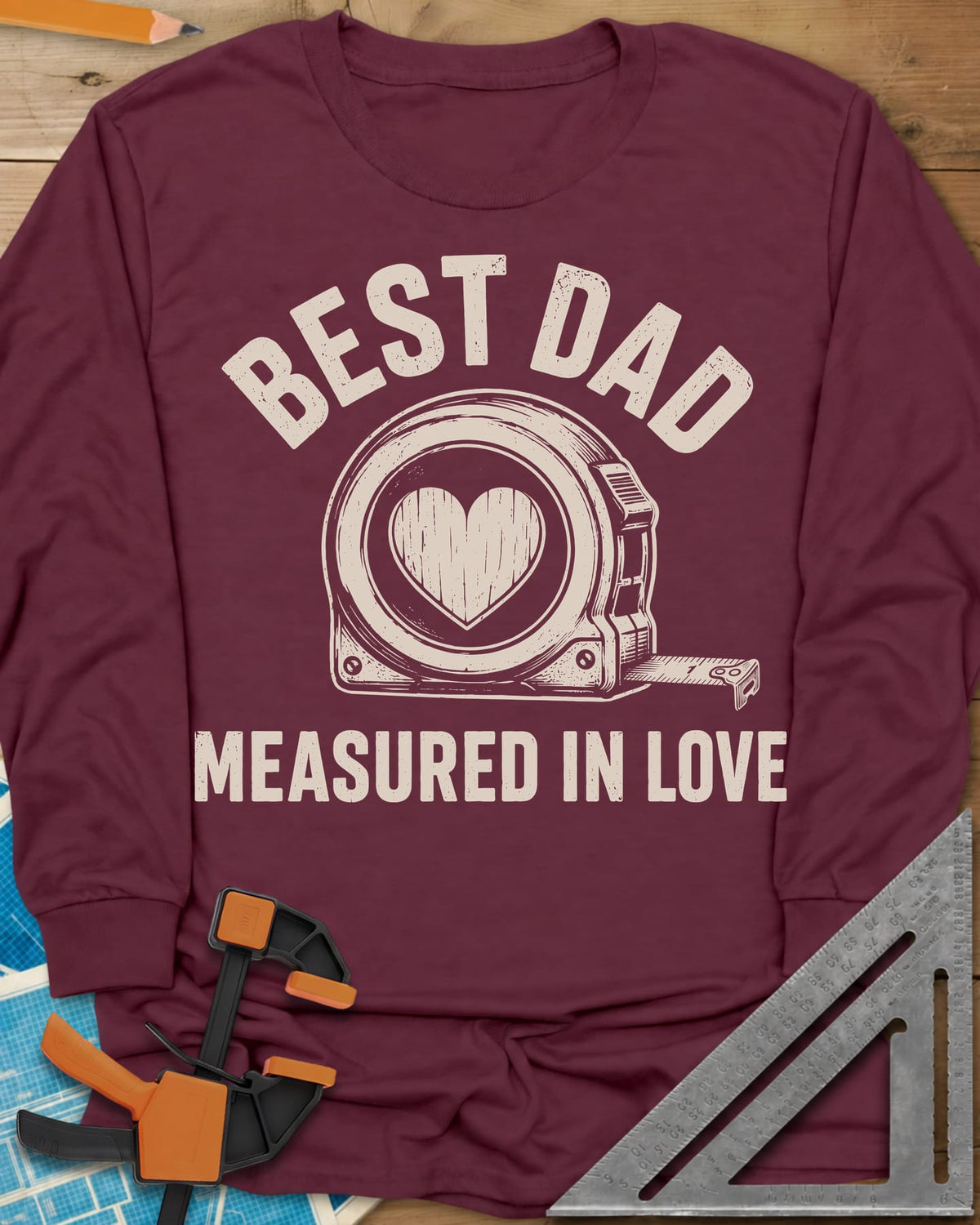 Best Dad Measured In Love long sleeve shirt in Maroon, a round tape measure with a wood-grain heart on its face