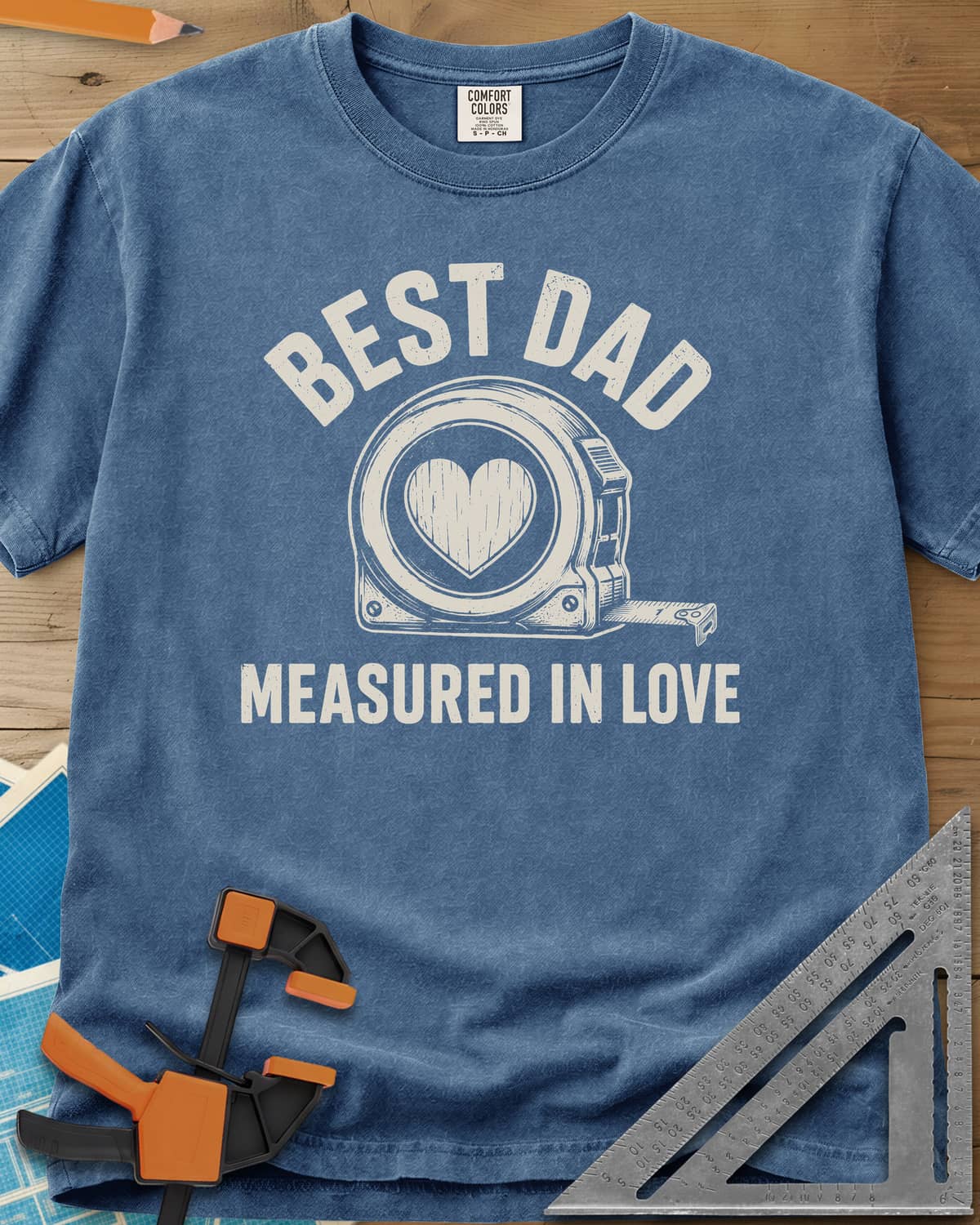 Best Dad Measured In Love heavyweight tee in Blue Jean, a round tape measure with a wood-grain heart on its face