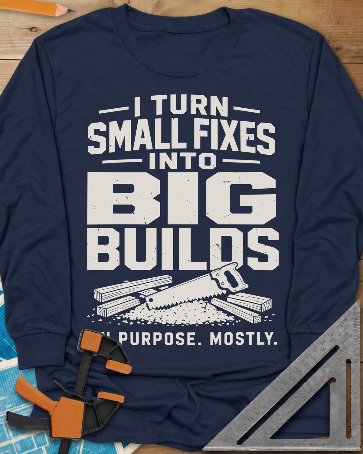 Big Builds long sleeve shirt in Navy, a handsaw resting on cut boards and a heap of sawdust