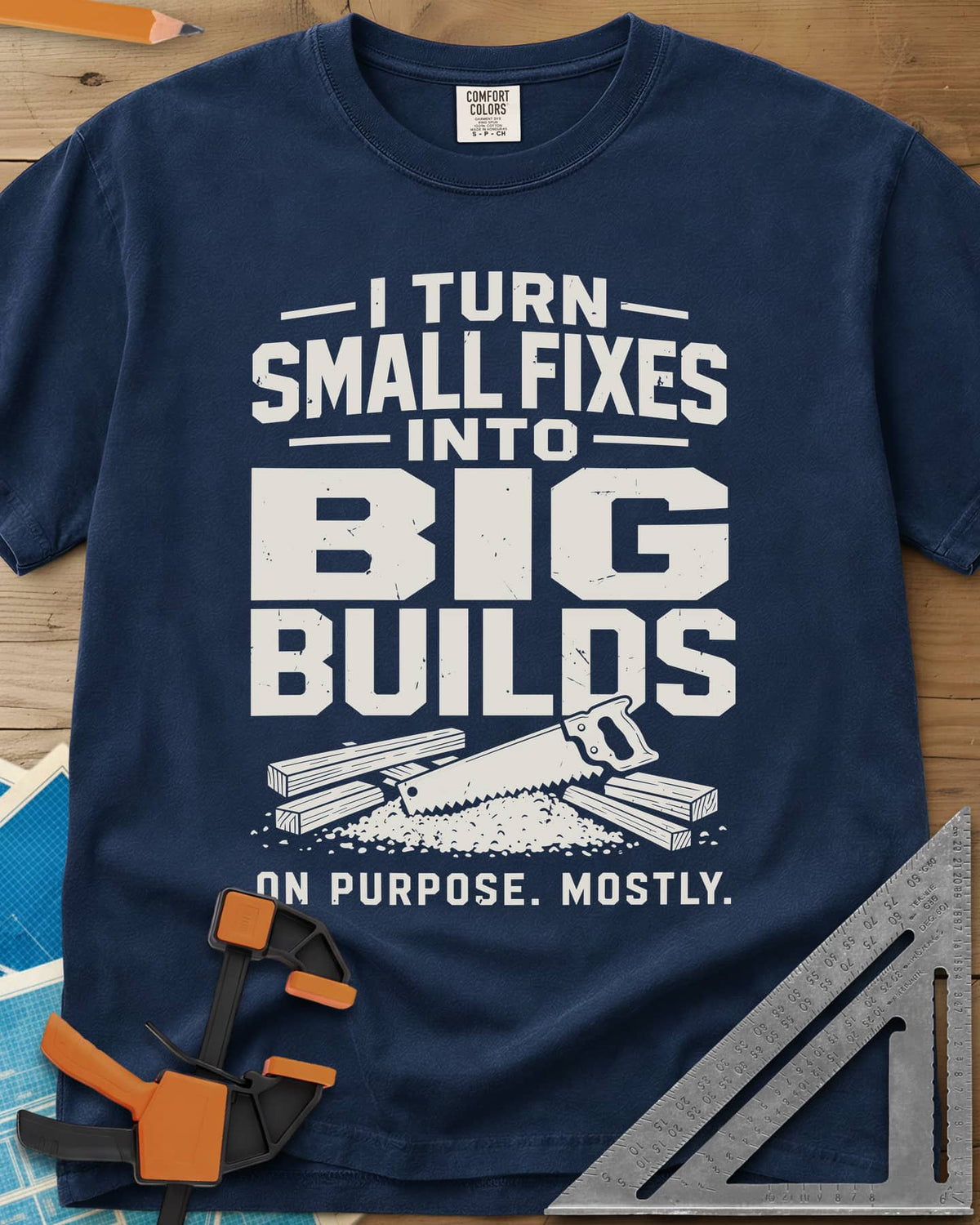 Big Builds heavyweight tee in Navy, a handsaw resting on cut boards and a heap of sawdust