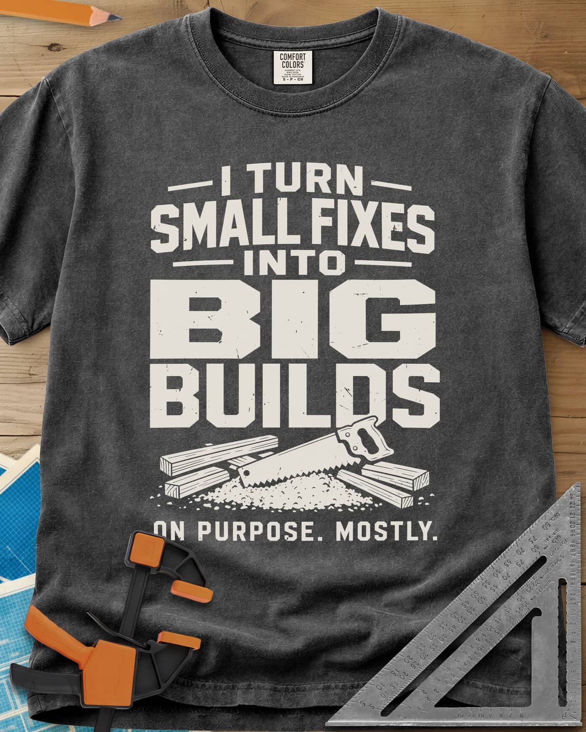 Big Builds heavyweight tee in Pepper, a handsaw resting on cut boards and a heap of sawdust