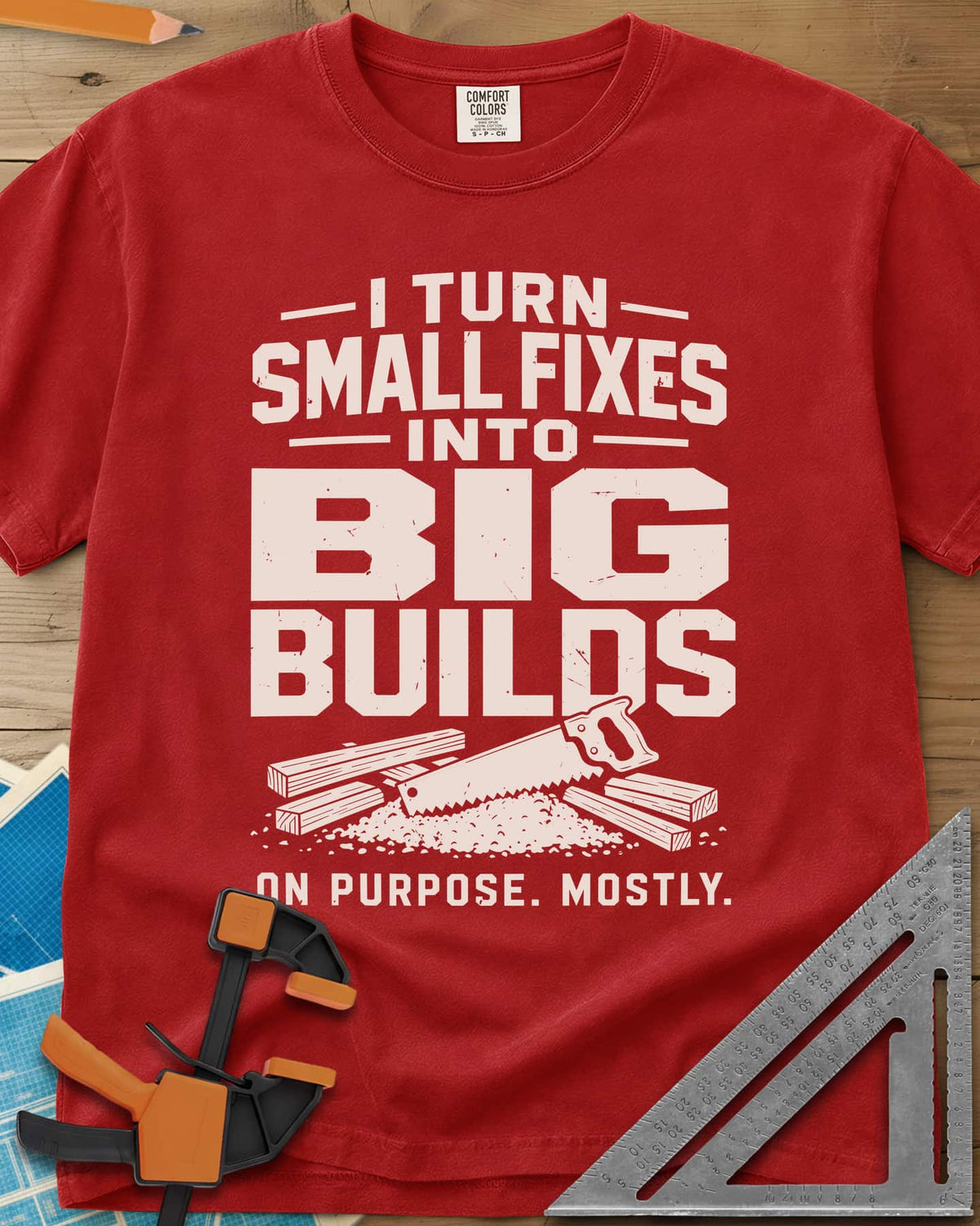 Big Builds heavyweight tee in Red, a handsaw resting on cut boards and a heap of sawdust