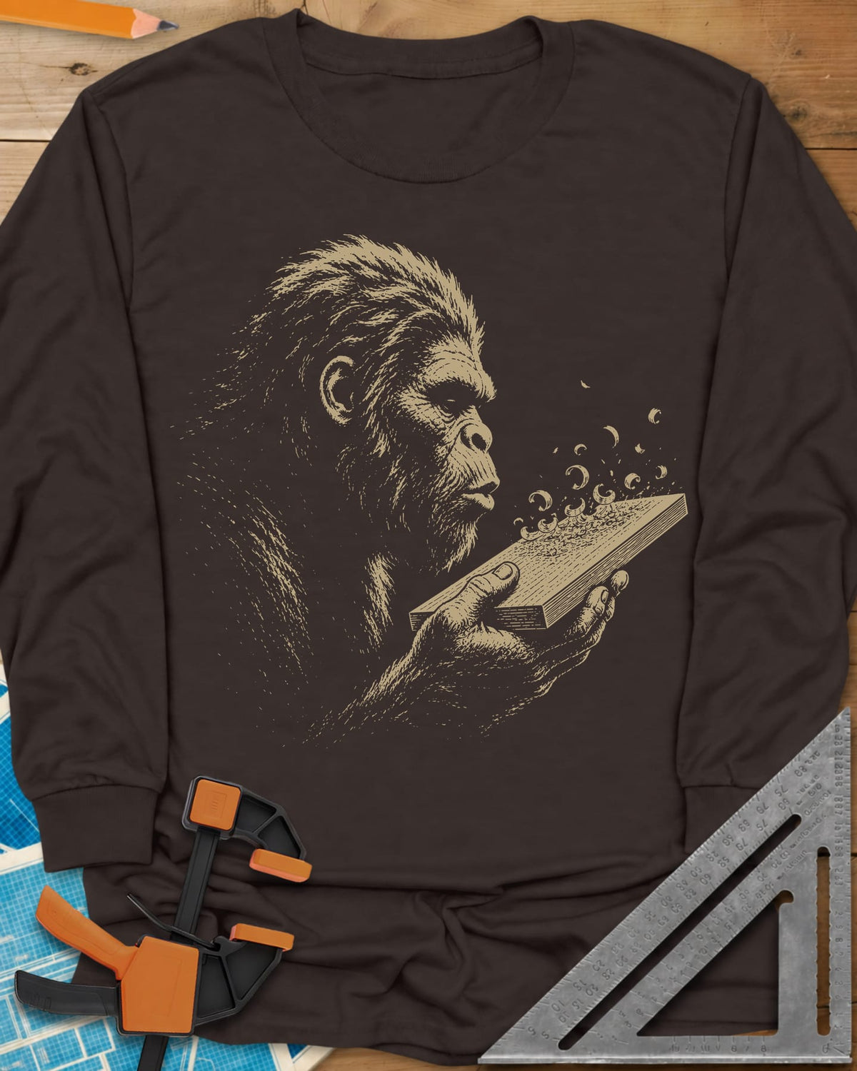 Bigfoot Blowing Sawdust long sleeve shirt in Dark Chocolate, Bigfoot in fine line work blowing sawdust curls off a board