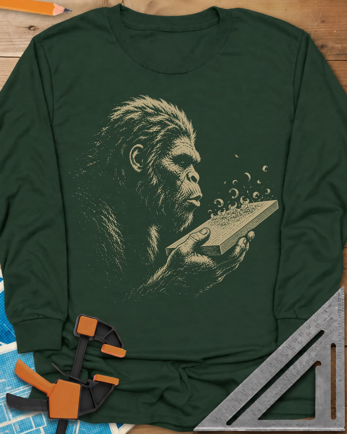 Bigfoot Blowing Sawdust long sleeve shirt in Forest Green, Bigfoot in fine line work blowing sawdust curls off a board