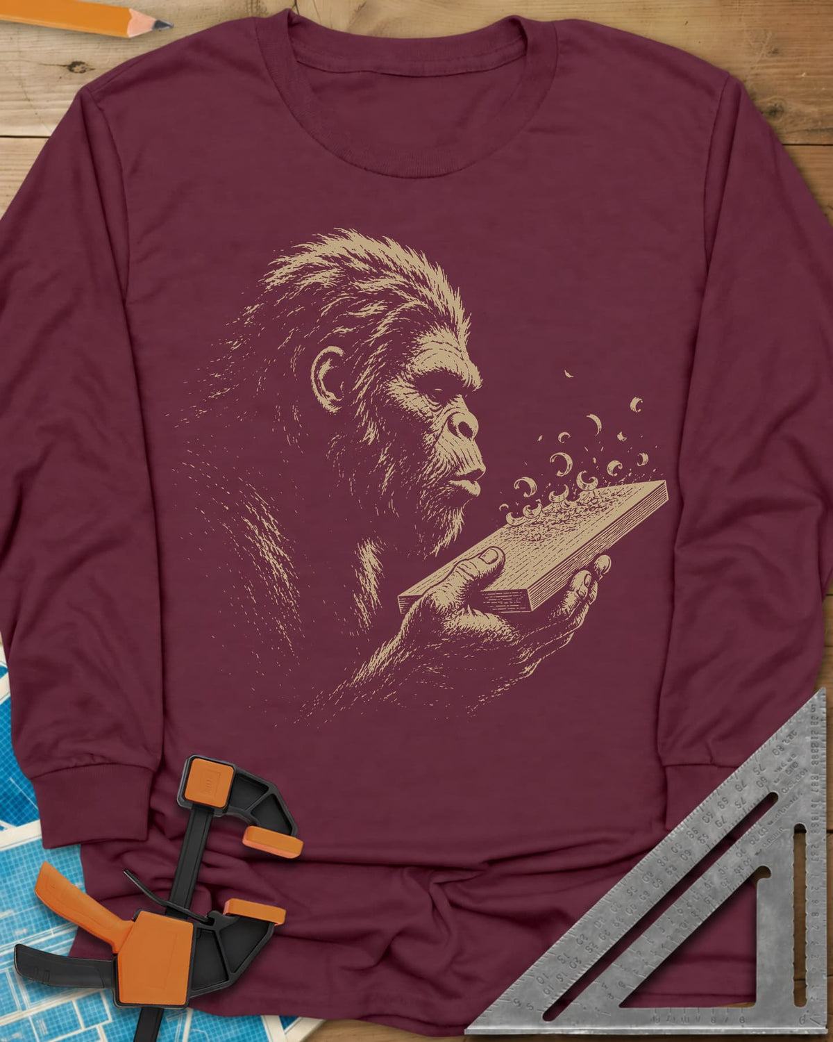 Bigfoot Blowing Sawdust long sleeve shirt in Maroon, Bigfoot in fine line work blowing sawdust curls off a board