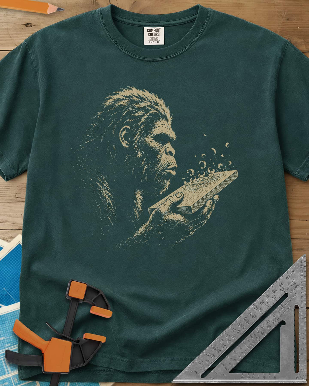 Bigfoot Blowing Sawdust heavyweight tee in Blue Spruce, Bigfoot in fine line work blowing sawdust curls off a board