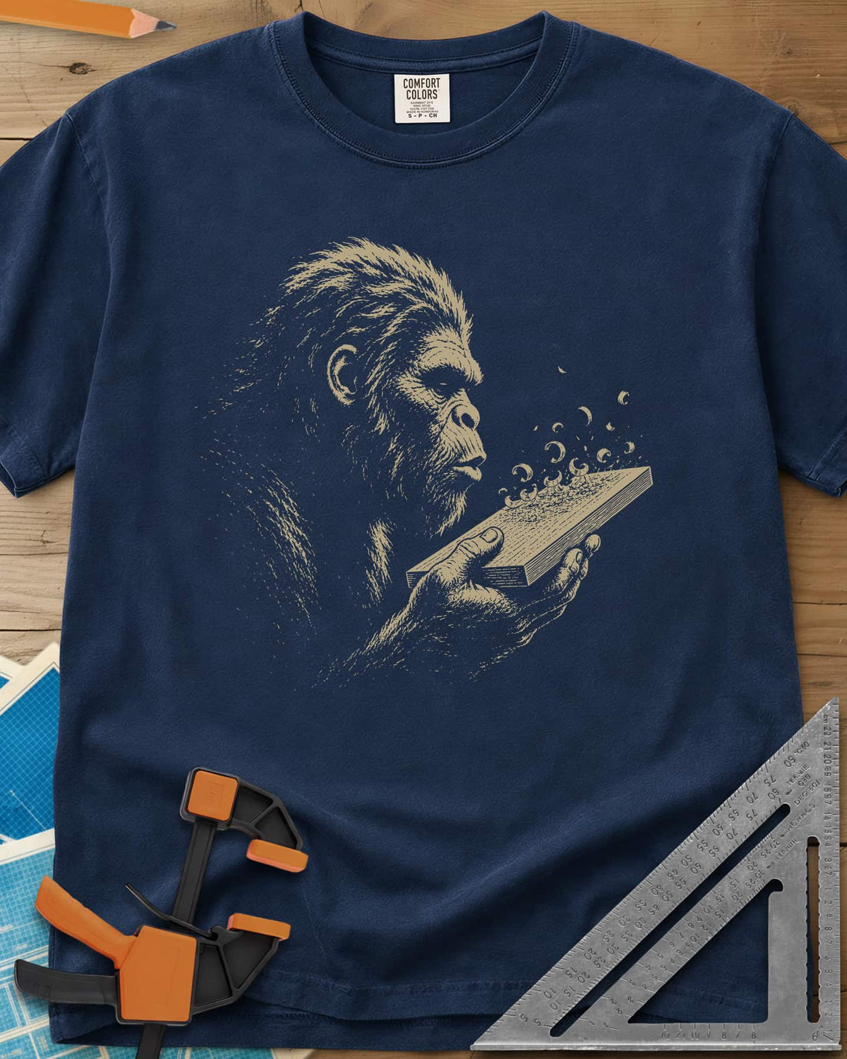 Bigfoot Blowing Sawdust heavyweight tee in Navy, Bigfoot in fine line work blowing sawdust curls off a board