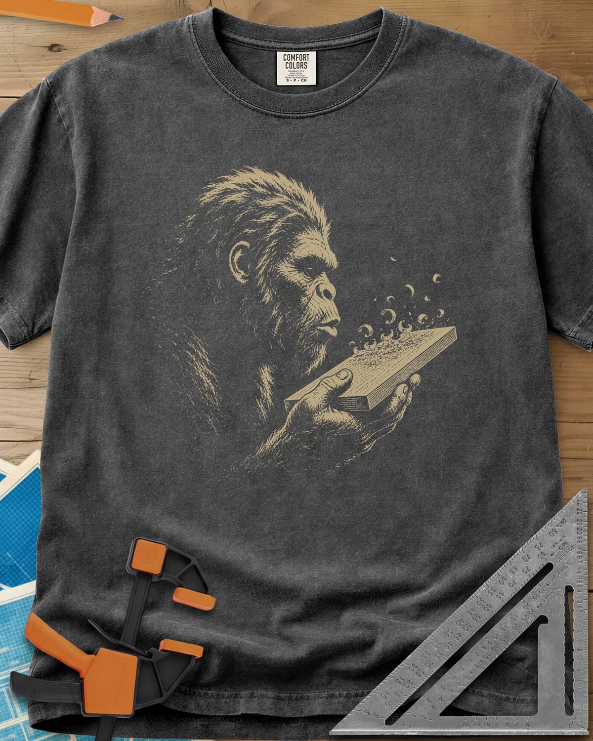 Bigfoot Blowing Sawdust heavyweight tee in Pepper, Bigfoot in fine line work blowing sawdust curls off a board