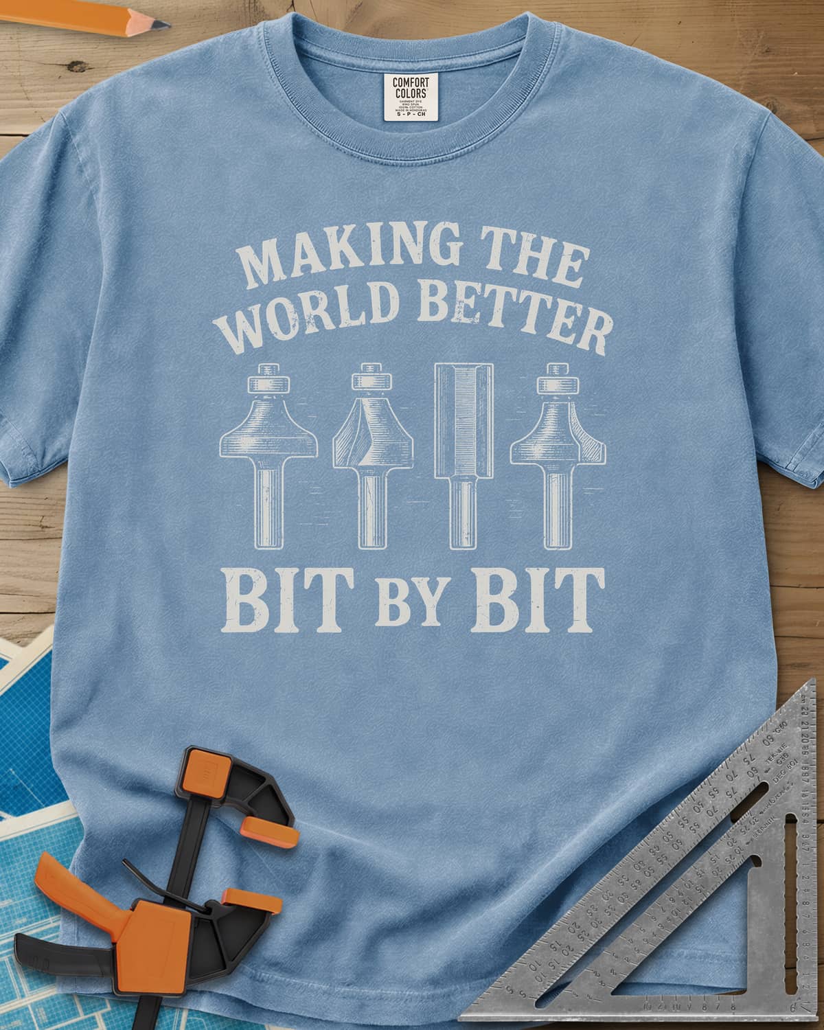 Bit by Bit heavyweight tee in Washed Denim, four engraved-style router bits between two lines of lettering