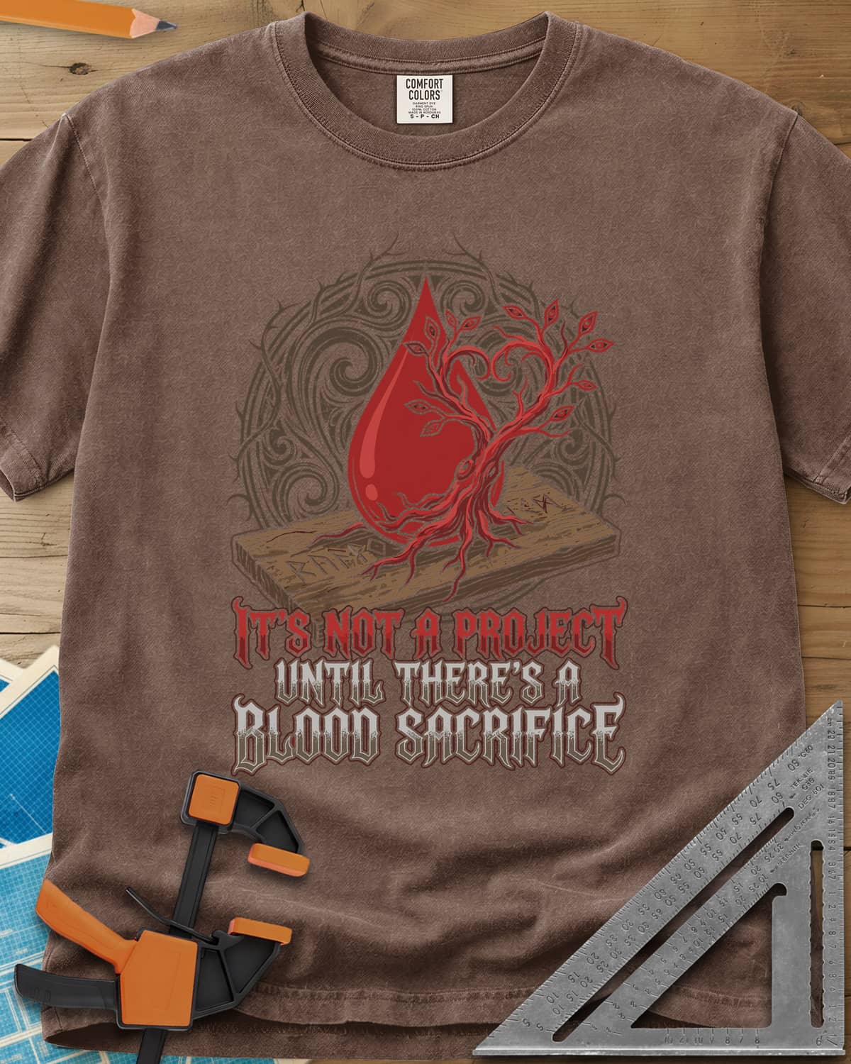 Blood Sacrifice heavyweight tee in Espresso, a blood drop and bare tree on a rune-carved board, gothic lettering