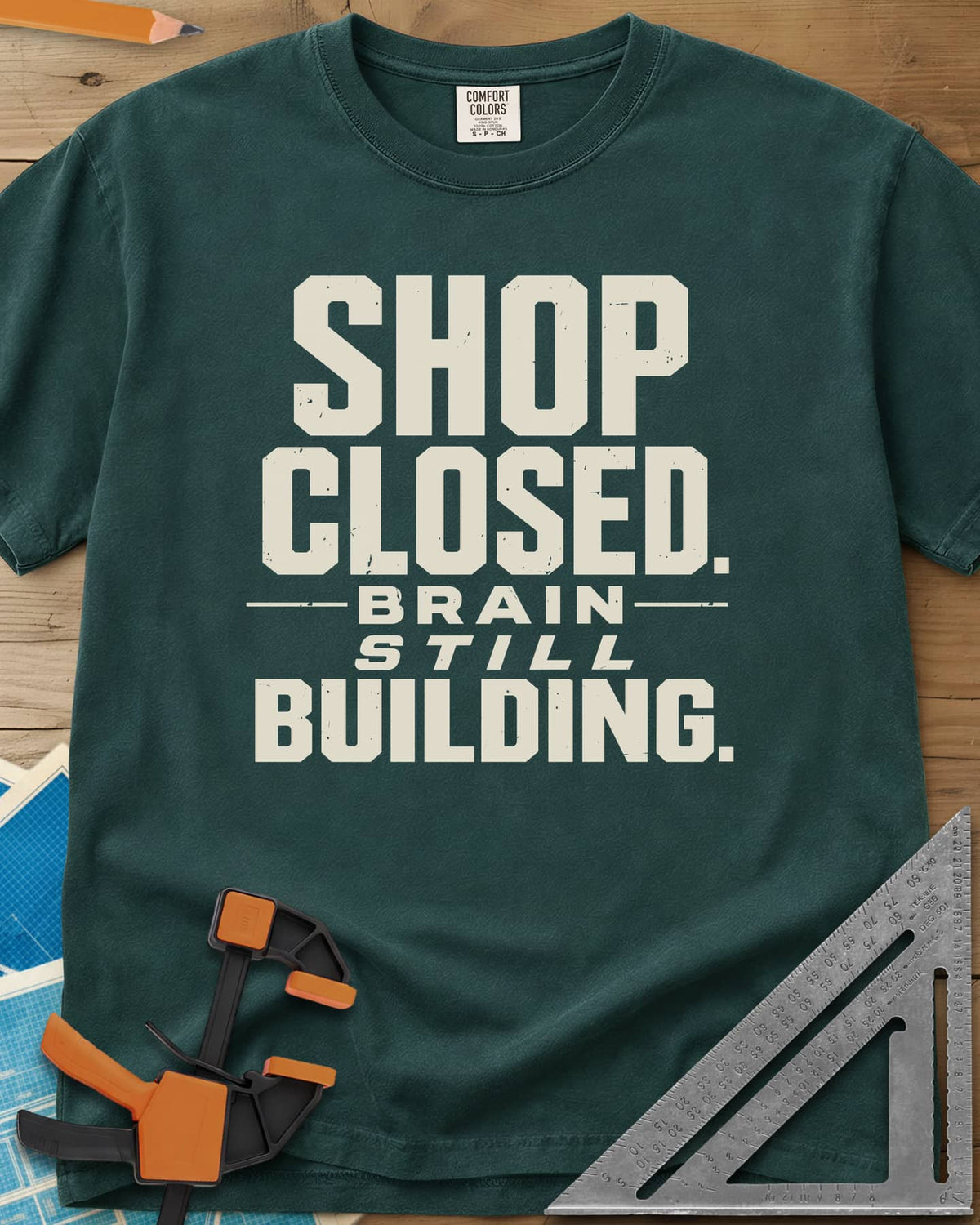 Brain Building heavyweight tee in Blue Spruce, stacked block lettering with STILL in italics, no graphic