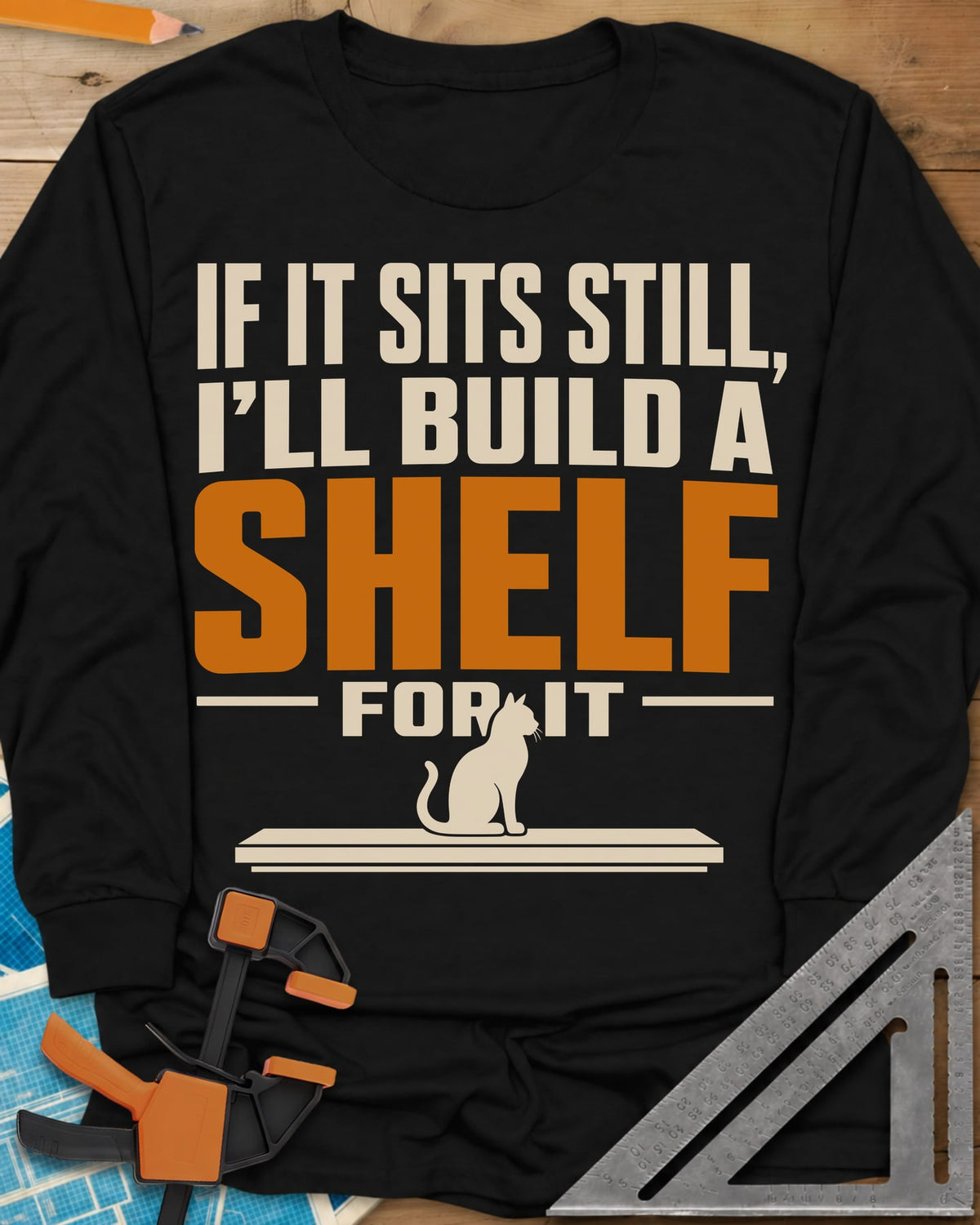 Build A Shelf long sleeve shirt in Black, a cat sitting on a plain shelf board under the words