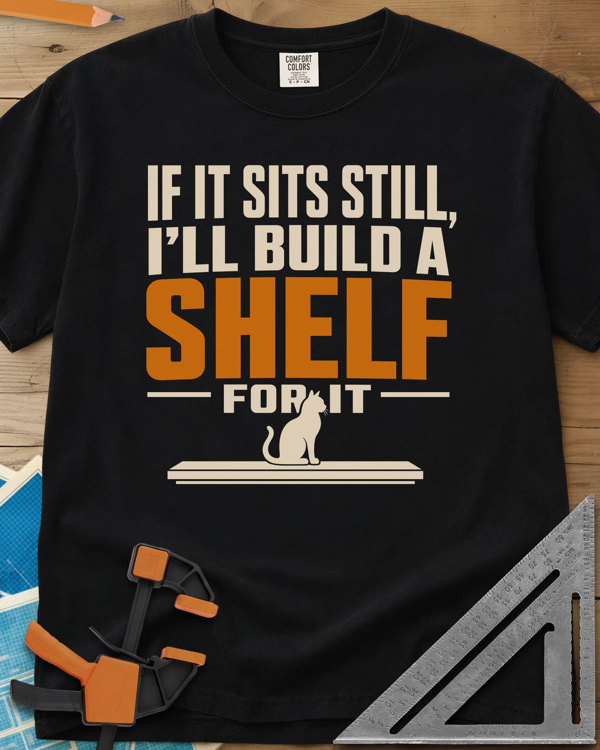 Build A Shelf heavyweight tee in Black, a cat sitting on a plain shelf board under the words