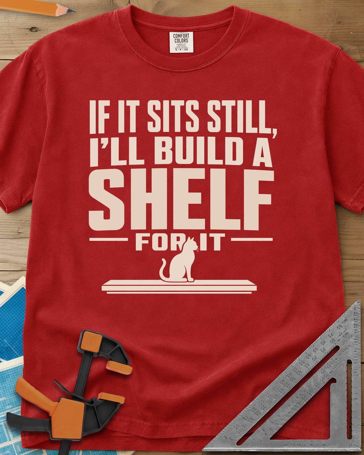 Build A Shelf heavyweight tee in Red, a cat sitting on a plain shelf board under the words