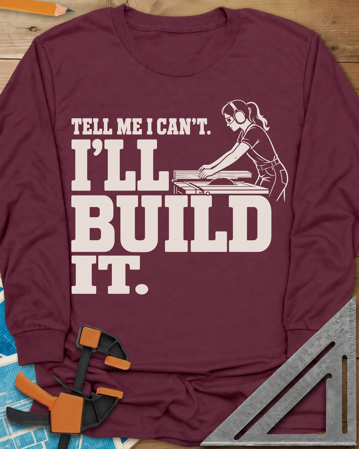 Build It long sleeve shirt in Maroon, a woman in ear protection and safety glasses at a table saw