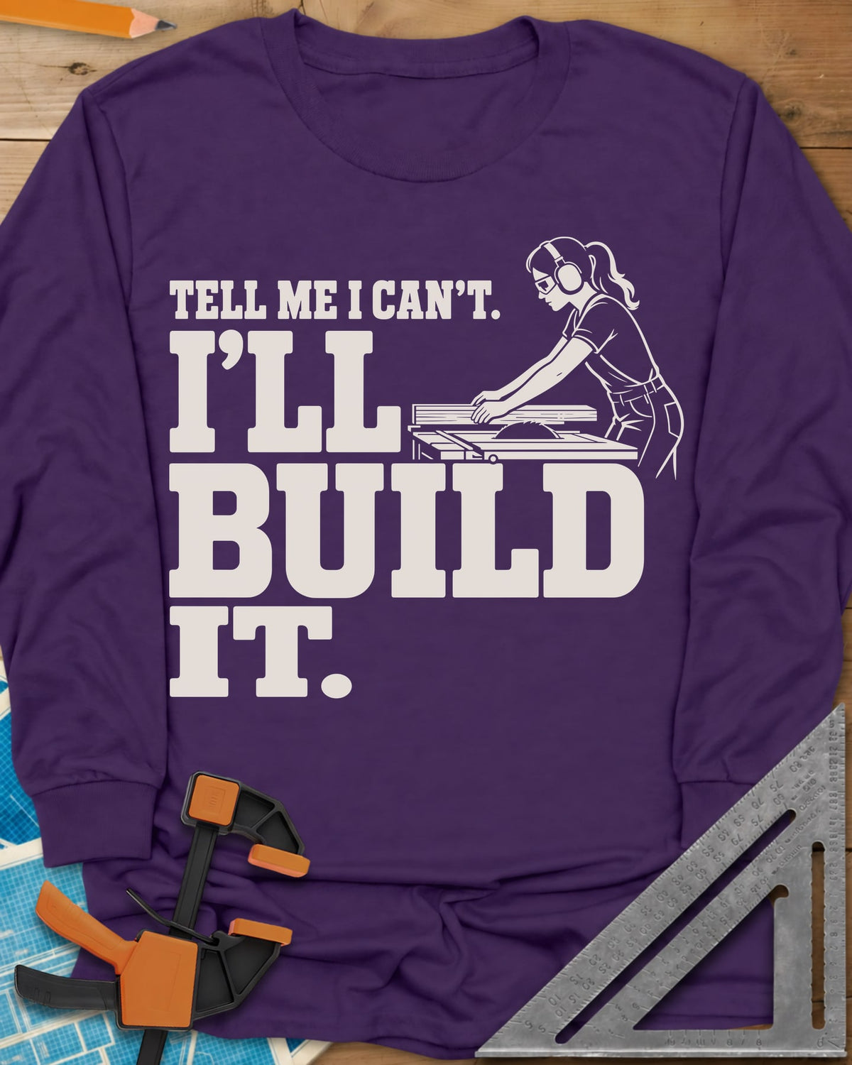 Build It long sleeve shirt in Purple, a woman in ear protection and safety glasses at a table saw