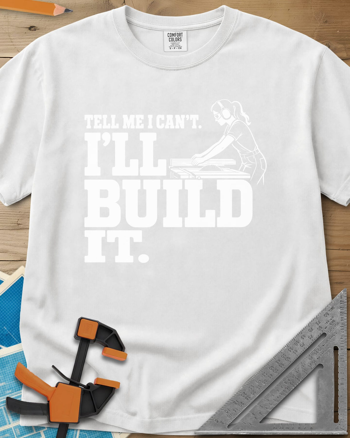 Build It heavyweight tee in White, a woman in ear protection and safety glasses at a table saw
