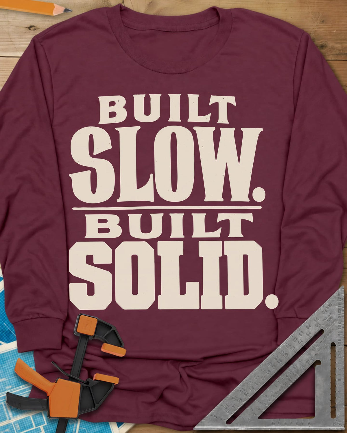Built Solid long sleeve shirt in Maroon, bold stacked wood-type lettering, no graphic